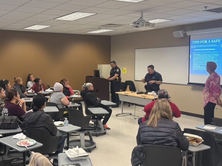 Caregivers attend a community safety presentation by local police officers in a Chelsea classroom