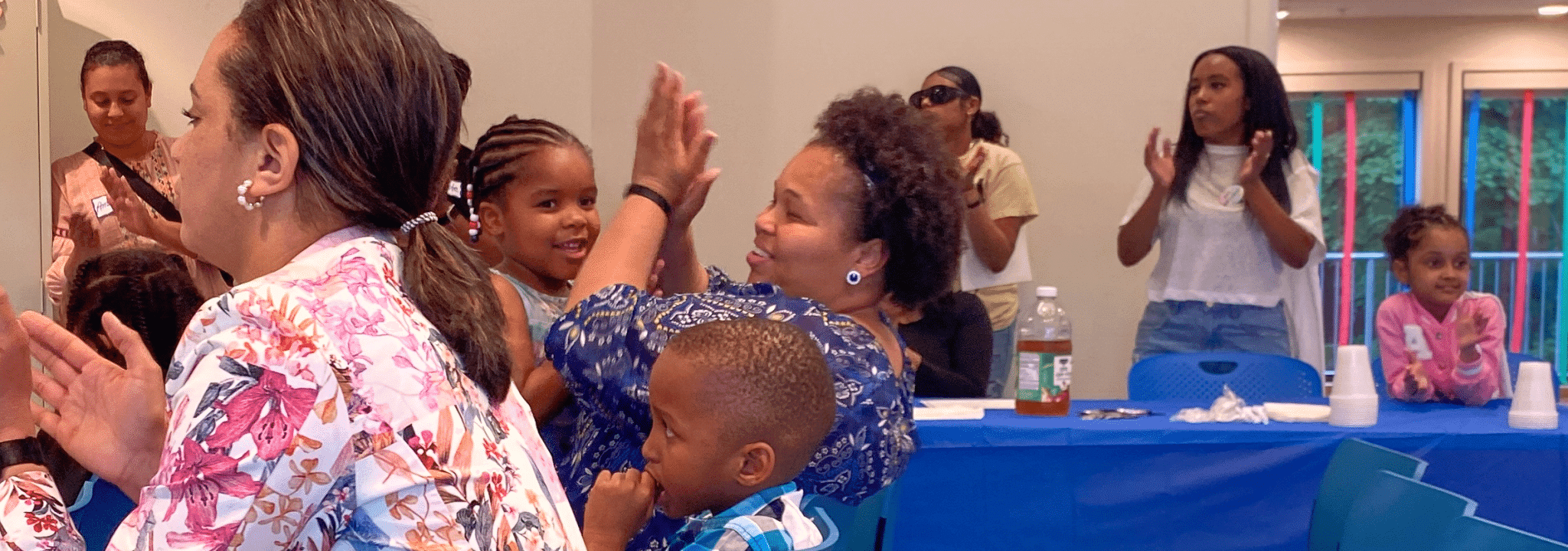 Caregivers and children clap and cheer together at an FNC community celebration.