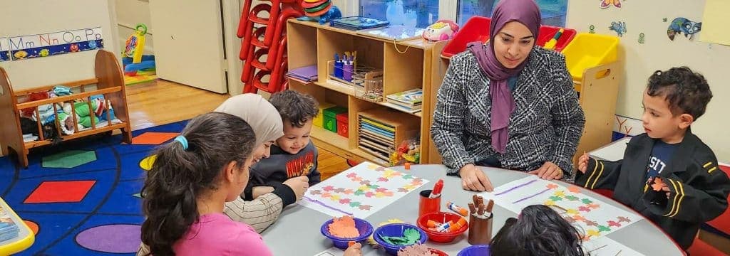 Children and caregivers making fall leaf crafts together around a table at FNC Hyde Park